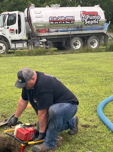Kyle from Dump N Pump Septic carefully uncovering a septic tank access lid in a customer's yard